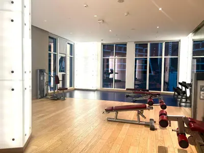 a gym with several exercise equipment in a room with windows at Luxury Studio Near Burj Khalifa in Dubai