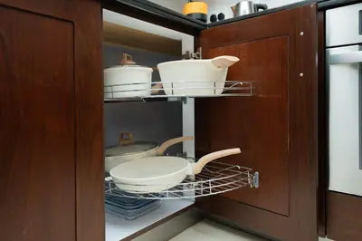 a cupboard with pots and pans in a kitchen at King 1BR Apartment With Burj Khalifa & Fountain View in Dubai