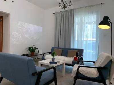 a living room with two blue couches and a table at Cozy home marina in Dubai