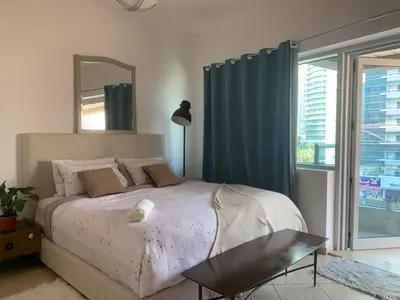 a bedroom with a bed with a mirror and a window at Cozy home marina in Dubai