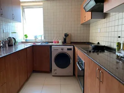 a kitchen with a washing machine in a kitchen at Cozy home marina in Dubai