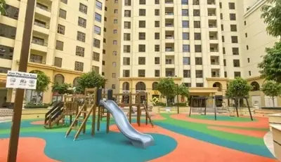 a playground in front of a building with a slide at ROYAL BEACH RESiDENCES 1 in Dubai