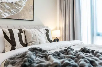a living room with a couch with a blanket at The Smart Concierge - Signature Grande in Dubai