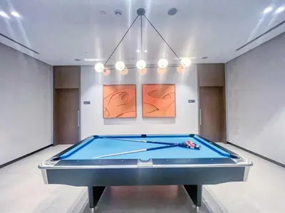 a pool table in the middle of a room at The Smart Concierge - Signature Grande in Dubai