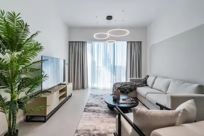 a living room with a couch and a tv at The Smart Concierge - Signature Grande in Dubai