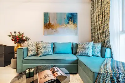 a living room with a blue couch at The Smart Concierge - Urban Oasis by Missoni in Dubai