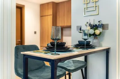 a dining room table with two chairs and glasses on it at The Smart Concierge - Urban Oasis by Missoni in Dubai