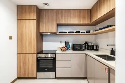 a small kitchen with wooden cabinets and appliances at The Smart Concierge - Urban Oasis by Missoni in Dubai