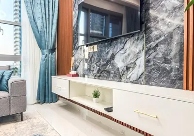 a living room with a large marble wall at DreamShoma -2BR Deluxe Downtown Skyview in Dubai