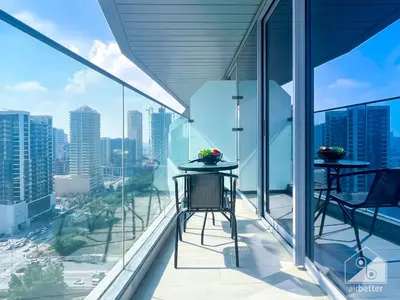 a balcony with two tables and views of the city at Stunning 1B With Balcony & City Views - Dubai in Dubai