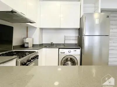 a kitchen with a stainless steel refrigerator and a dishwasher at Stunning 1B With Balcony & City Views - Dubai in Dubai