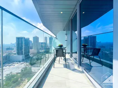 a balcony with two chairs and views of the city at Stunning 1B With Balcony & City Views - Dubai in Dubai