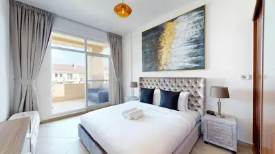 a bedroom with a large bed and a large window at Widcombe House - Tranquil One Bed in Motor City in Dubai
