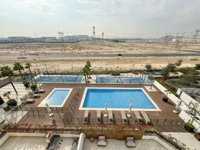 an overhead view of two swimming pools with chairs at Serene 1-Bedroom Retreat in Azizi Riviera with Calming Tones in Dubai