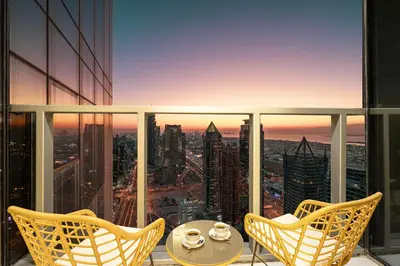 a balcony with a table and chairs and a view of a city at Famous Infinity Pool 64th floor near Burj Khalifa in Dubai