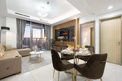 a living room with a table and chairs and a couch at Famous Infinity Pool 64th floor near Burj Khalifa in Dubai