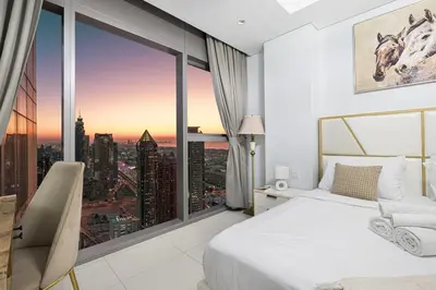 a bedroom with a bed and a large window at Famous Infinity Pool 64th floor near Burj Khalifa in Dubai