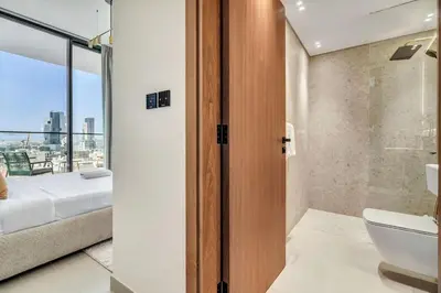 a bathroom with a toilet and a bed and a window at GuestReady - Prestigious haven in JVC in Dubai