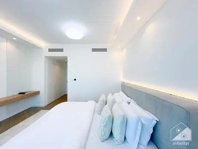 a bedroom with a bed with blue pillows on it at Spacious 2B Apt with Full Marina Views - Delphine in Dubai