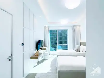 a white bedroom with two beds and a window at Spacious 2B Apt with Full Marina Views - Delphine in Dubai