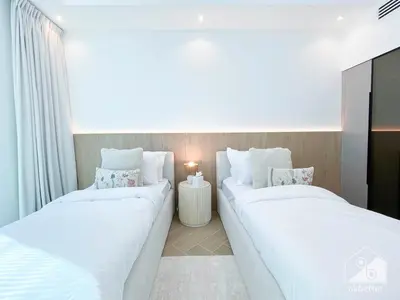 two white beds in a room with a tv at Spacious 2B Apt with Full Marina Views - Delphine in Dubai