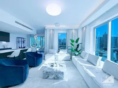 a living room with a white couch and blue chairs at Spacious 2B Apt with Full Marina Views - Delphine in Dubai