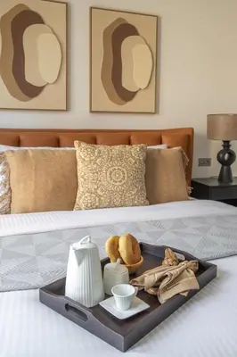 a tray on a bed with food on it at Frank Porter - Reehan 7 in Dubai