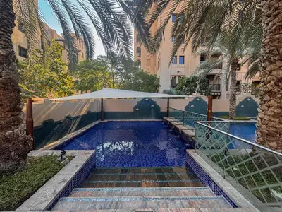 a swimming pool with stairs leading to a building at Frank Porter - Reehan 7 in Dubai