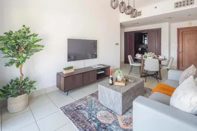 a living room with a couch and a tv at Frank Porter - Reehan 7 in Dubai