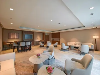 a waiting room with couches and tables and chairs at Stylish 1BR in Act One, Downtown Near Burj Khalifa in Dubai