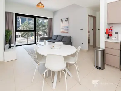 a kitchen and living room with a white table and chairs at Stylish 1BR in Act One, Downtown Near Burj Khalifa in Dubai