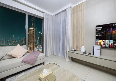 a living room with a couch and a large window at Amazing 2BR Home Burj Khalifa View Steps Walk to DubaiMall in Dubai
