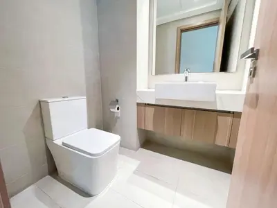 a bathroom with a toilet and a sink and a mirror at Brand New Spacious 3-BedroomIAzizi Riviera 16 in Dubai