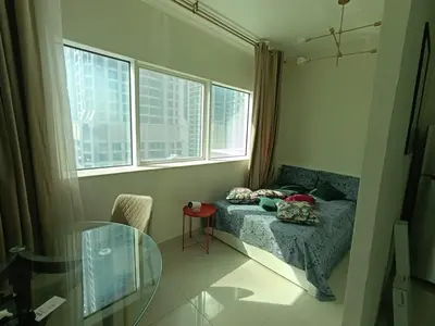 a small bedroom with a bed and a glass table at In the heart of Dubai in Dubai