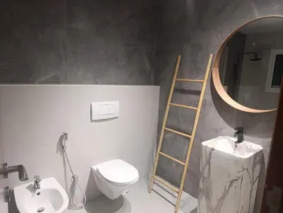 a bathroom with a ladder next to a toilet and a mirror at In the heart of Dubai in Dubai