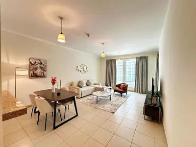 a living room with a table and a couch at Step into Sophistication - Stylish 1-BR Apartment in Downtown Dubai by petals Holiday Homes in Dubai