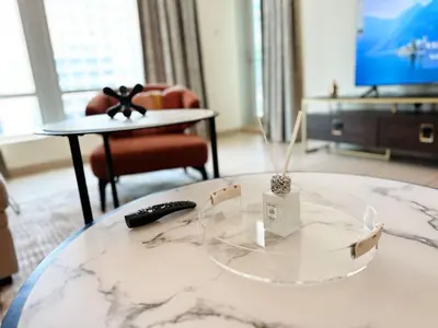 a glass coffee table in a living room with a television at Step into Sophistication - Stylish 1-BR Apartment in Downtown Dubai by petals Holiday Homes in Dubai