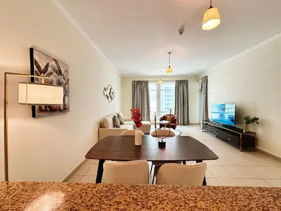 a living room with a table and a couch at Step into Sophistication - Stylish 1-BR Apartment in Downtown Dubai by petals Holiday Homes in Dubai