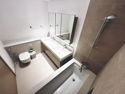 a bathroom with a tub and a toilet and a sink at Coastal Charm - Fully Furnished 2-Bedroom Apartment with Spectacular Views by Petals Holiday Homes in Dubai