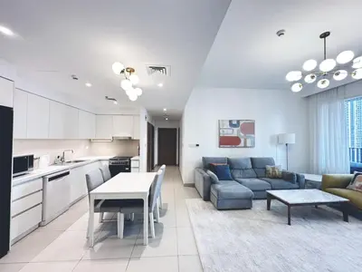 a kitchen and living room with a couch and a table at Coastal Charm - Fully Furnished 2-Bedroom Apartment with Spectacular Views by Petals Holiday Homes in Dubai