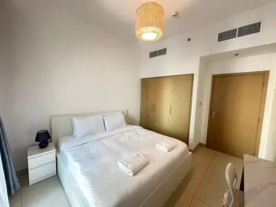 a bedroom with a large white bed with two pillows at Coastal Charm - Fully Furnished 2-Bedroom Apartment with Spectacular Views by Petals Holiday Homes in Dubai