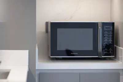 a microwave sitting on a shelf in a kitchen at Seaside Serenity 1Bd Beachfront Apartment in Dubai