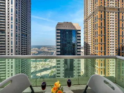 a view of a city from a balcony with glasses of wine at Spacious 3BR High Floor Palm View in Dubai Marina in Dubai