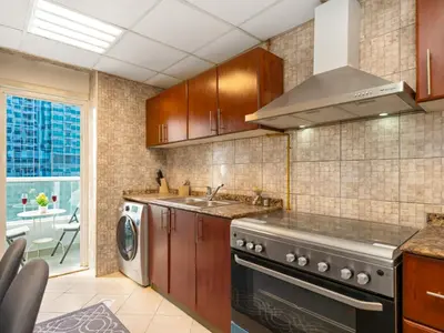 a kitchen with a stove and a sink and a dishwasher at Spacious 3BR High Floor Palm View in Dubai Marina in Dubai