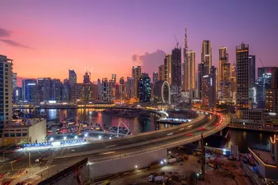 a city skyline at night with a busy freeway at Elegant 2BR with Balcony and Burj Khalifa Skyline Views in Dubai