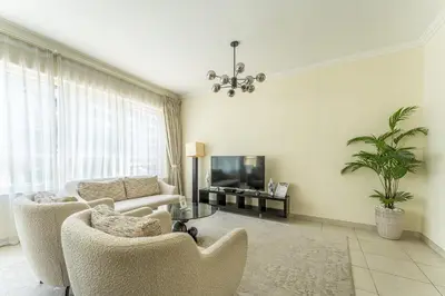 a living room with two chairs and a television at HAVN - 2 Bedroom in Marina Quays, Dubai Marina in Dubai