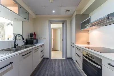 a kitchen with white cabinets and a sink at HAVN - 2 Bedroom in Marina Quays, Dubai Marina in Dubai