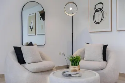 a living room with two chairs and a table at Huge Sky Villa With Panoramic Golf Views in Dubai