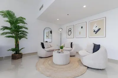 a living room with three chairs and a table at Huge Sky Villa With Panoramic Golf Views in Dubai