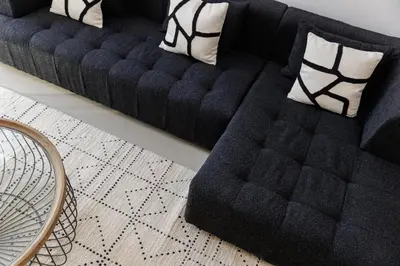 a black couch sitting in a living room with pillows at Huge Sky Villa With Panoramic Golf Views in Dubai
